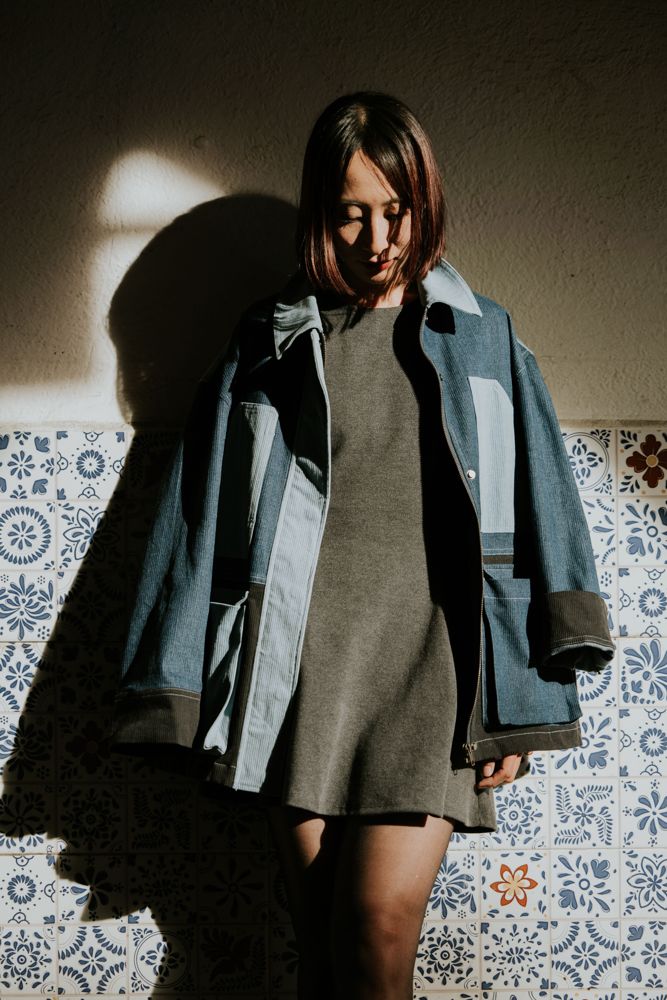 Veste patchwork en jean portée sur une robe grise, lumière d'automne